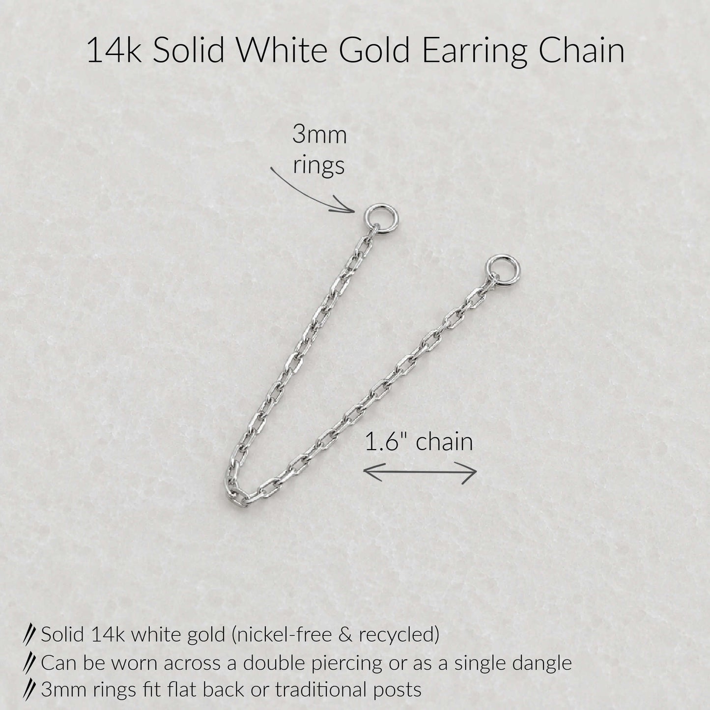 A 14k solid white gold earring chain shown on a light textured background with measurement annotations indicating 3mm rings and a 1.6-inch chain length, plus product feature text.