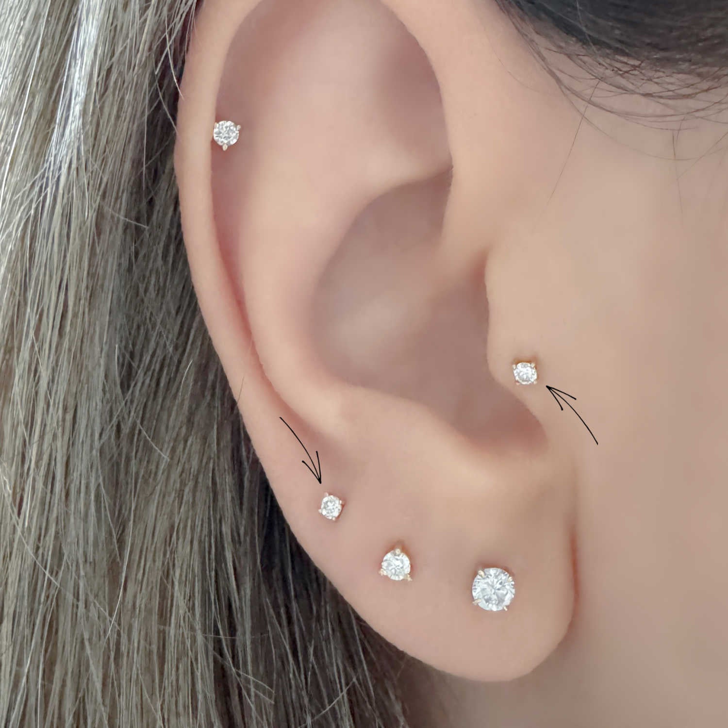 Woman Wearing Lab Grown Diamond Stud Earrings in Helix, Tragus & Lobe | 14k Gold Flat Back Cartilage Piercing Studs from Two of Most