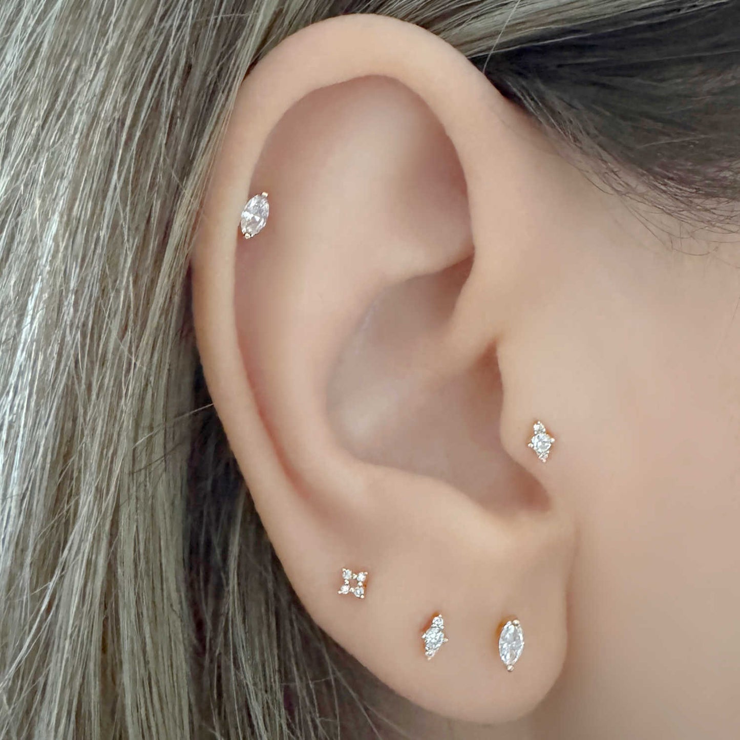Woman Wearing 14k Marquise Cut & 3-Stone Lab Grown Diamond Stud Earrings in Helix, Tragus & Lobe