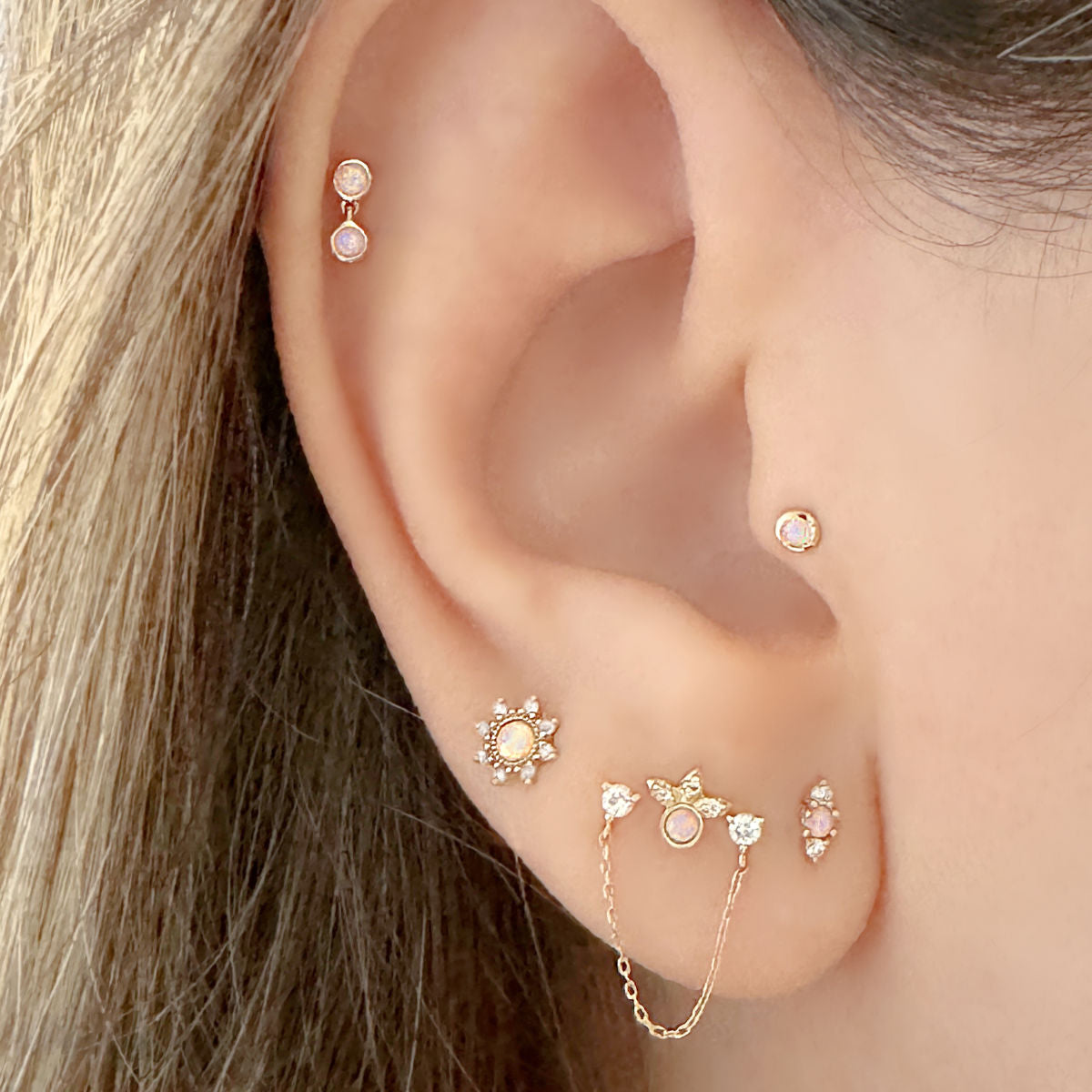 Woman Wearing Opal Helix, Tragus, Conch and Earrings | 14k Flat Back Studs from Two of Most