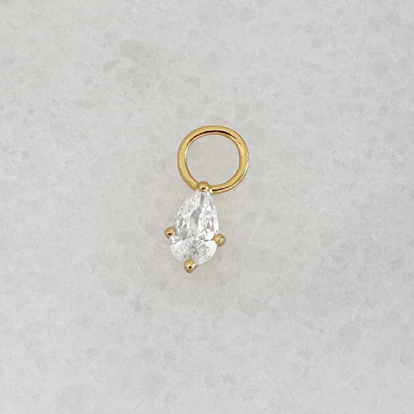 Gold hoop earring charm with a pear teardrop-shaped cubic zirconia gemstone