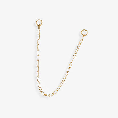A delicate 14k yellow gold paperclip chain earring charm with two circular jump ring ends, displayed on a clean, light off-white background.