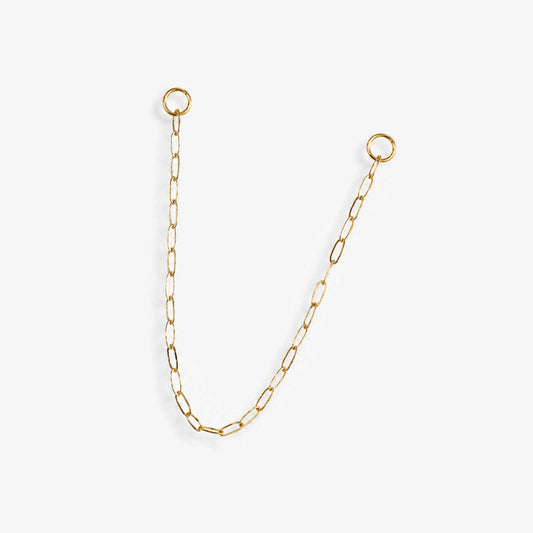 A delicate 14k yellow gold paperclip chain earring charm with two circular jump ring ends, displayed on a clean, light off-white background.