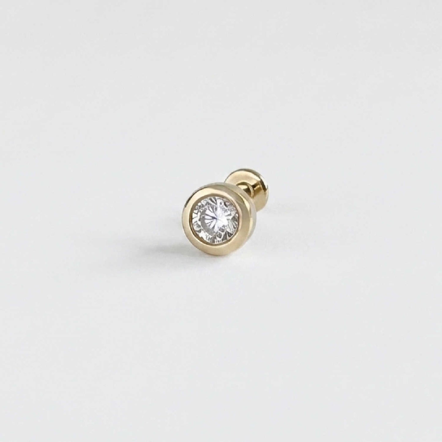 A single 14k solid gold stud flat back earring with a bezel-set diamond gemstone, shown on a clean, light gray background.