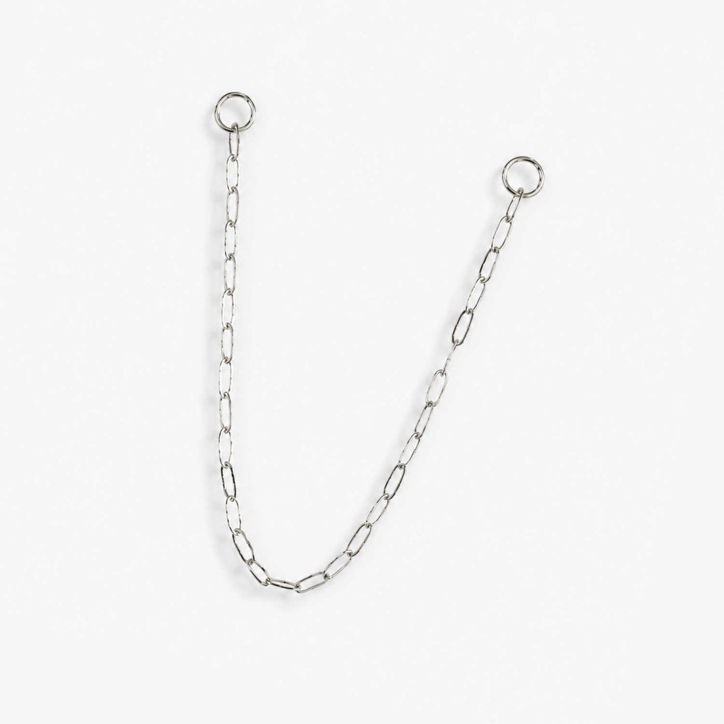 A delicate 14k white gold paperclip chain earring charm with two circular jump ring ends, displayed on a clean, light off-white background.