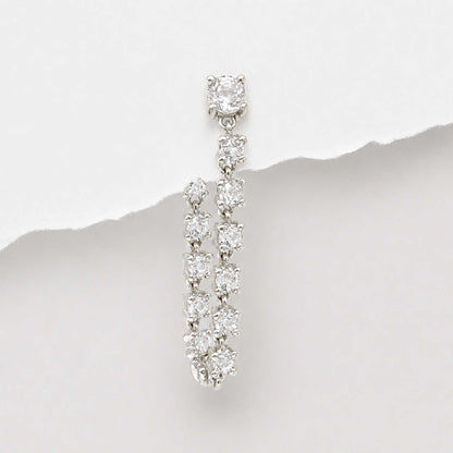 A 14k white gold flat back tennis style dangle earring with multiple round-cut diamonds, photographed against a white background with a torn-paper style divider.