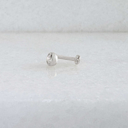 Side view of a single 14k solid white gold stud flat back earring with a bezel-set diamond gemstone, shown on a light gray background.