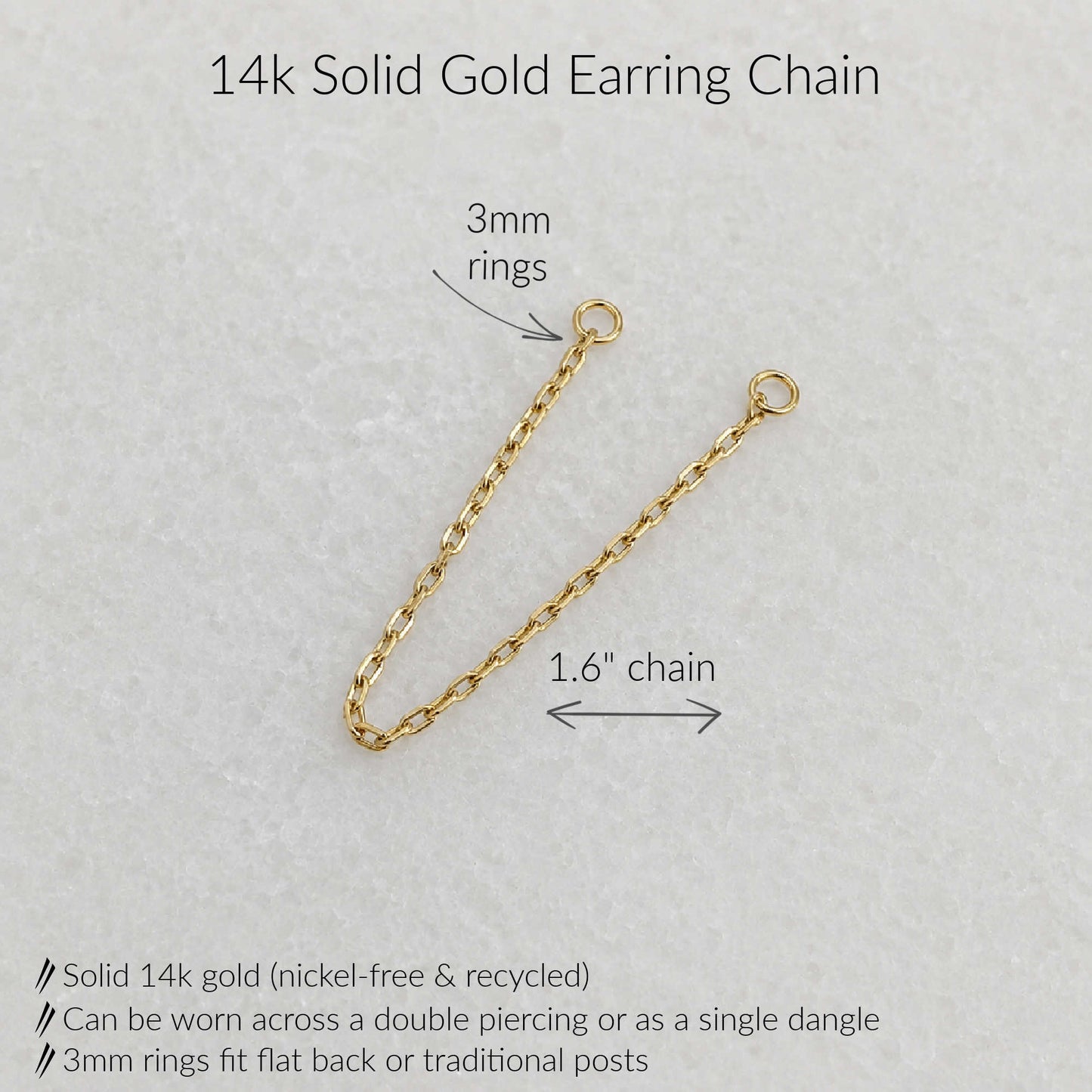 A 14k solid gold earring chain with two 3mm rings and a 1.6-inch chain length, shown on a light textured background with text labels and product details.