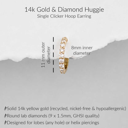 A 14k yellow gold single-clicker huggie hoop earring with round lab diamonds, shown on a light gray background with text detailing its dimensions (11mm outer diameter, 8mm inner diameter) and material specifications.