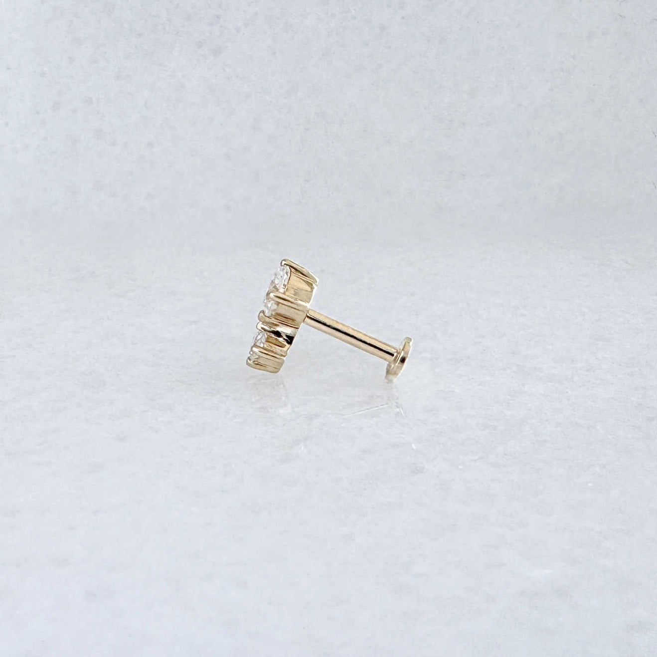 Side view of a solid 14k gold flat back stud earring with 1/2 Carat of diamonds 
