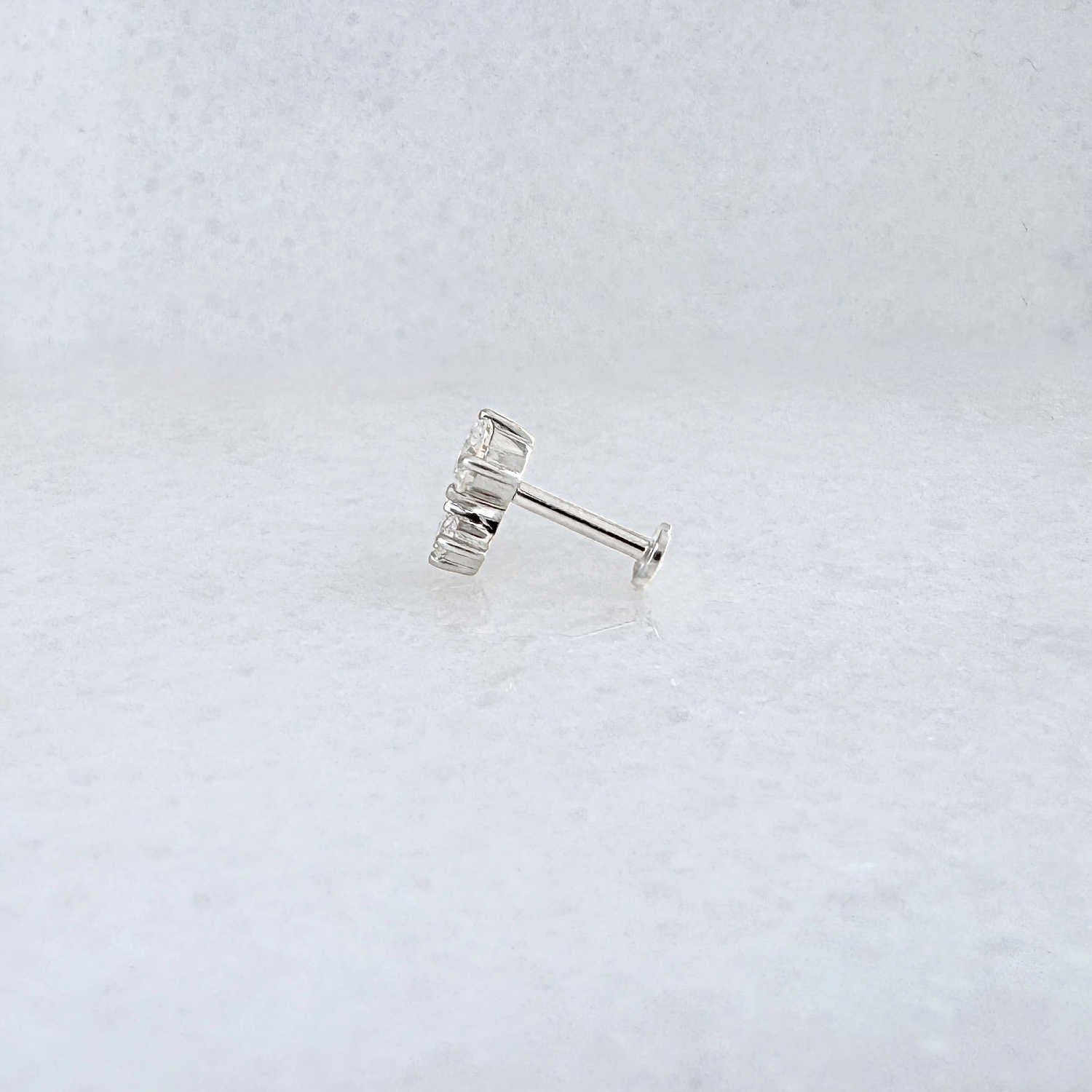 Side view of a solid 14k gold flat back stud earring with 1/2 Carat of diamonds 