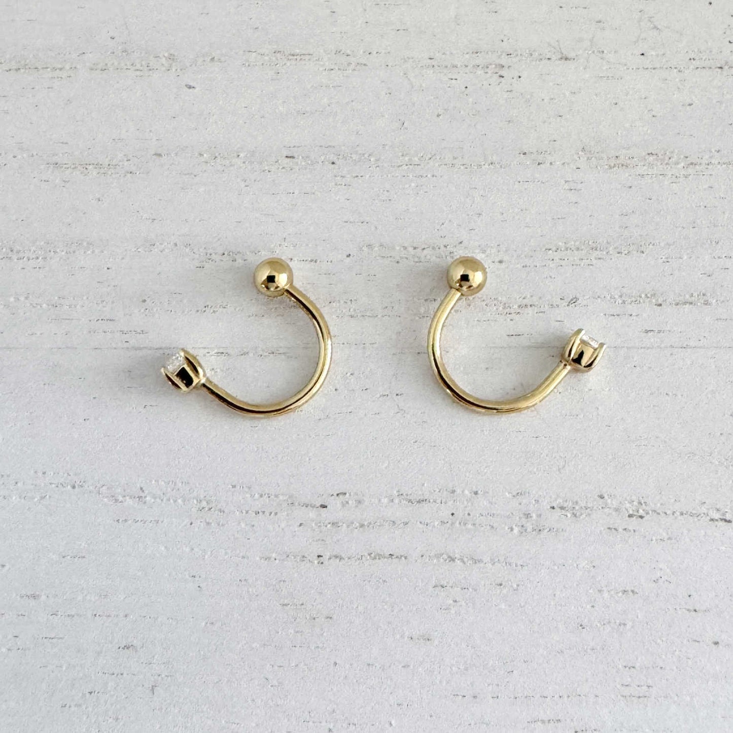 Pair of gold front to back hoop earrings, side view