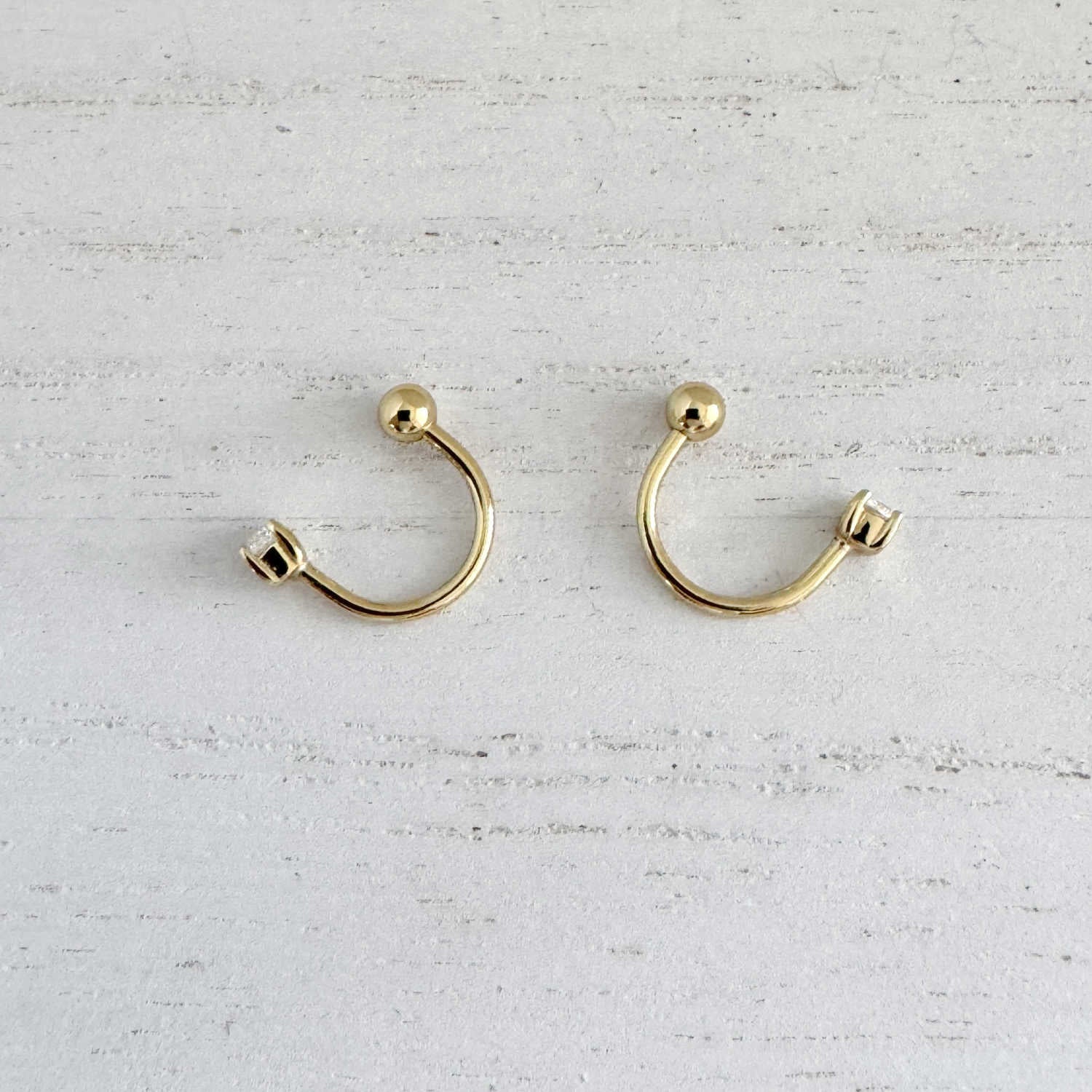 Pair of gold front to back hoop earrings, side view