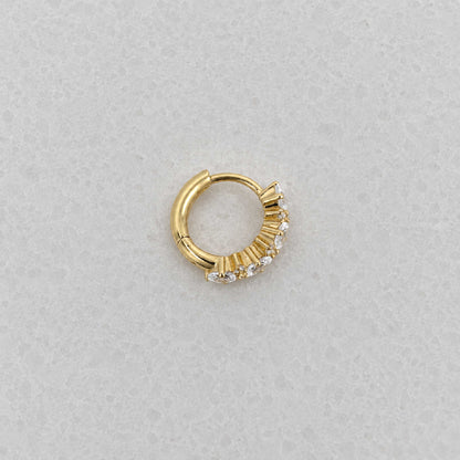 Side view of 14k gold plated huggie hoop earring with a vertical cluster of clear oval-cut and round stones