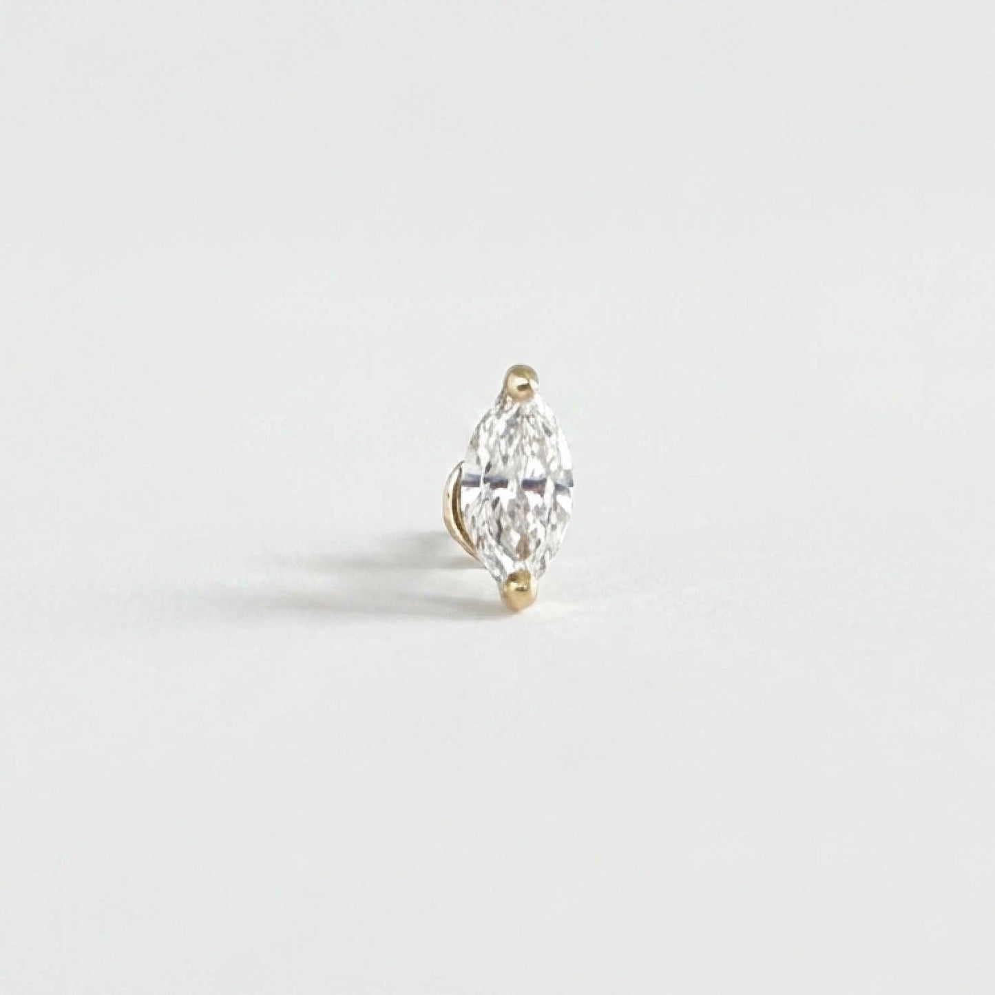 A single marquise-cut diamond stud Flat Back Cartilage Piercing earring in a 14k yellow gold setting, photographed on a clean, light gray background.