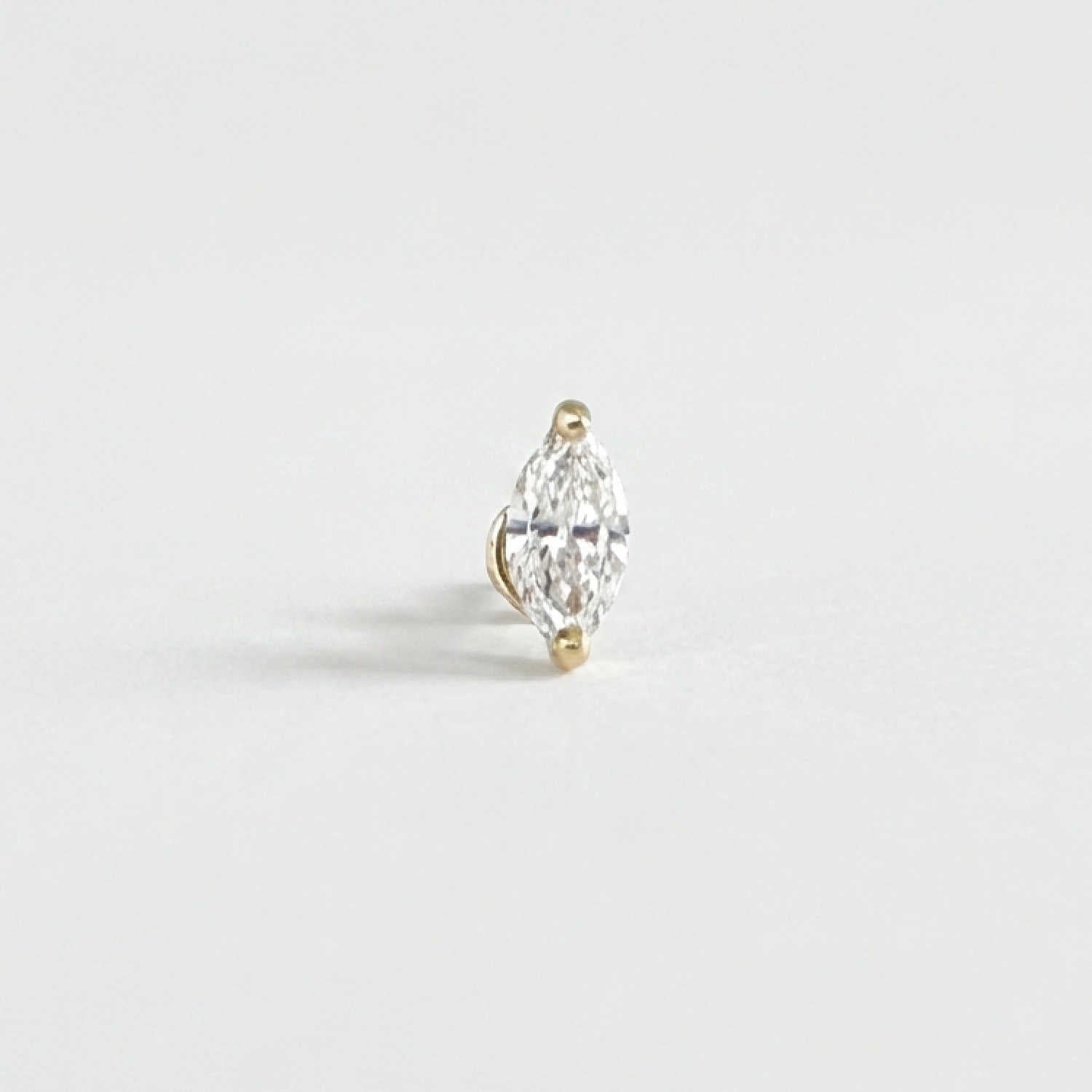 A single marquise-cut diamond stud Flat Back Cartilage Piercing earring in a 14k yellow gold setting, photographed on a clean, light gray background.