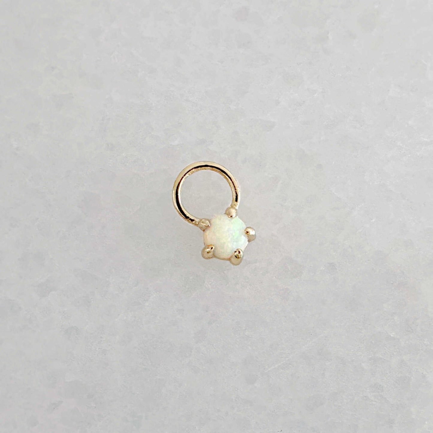 Gold hoop earring charm with a round opal gemstone