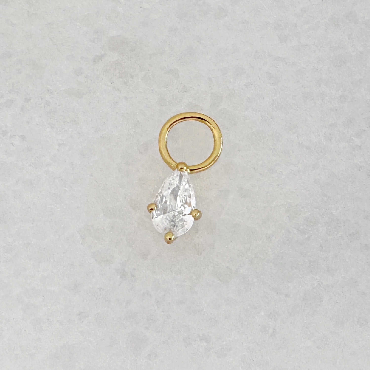 Gold hoop earring charm with a pear teardrop-shaped cubic zirconia gemstone