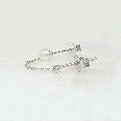 Pearl double piercing stud earrings with sterling silver chains, side view