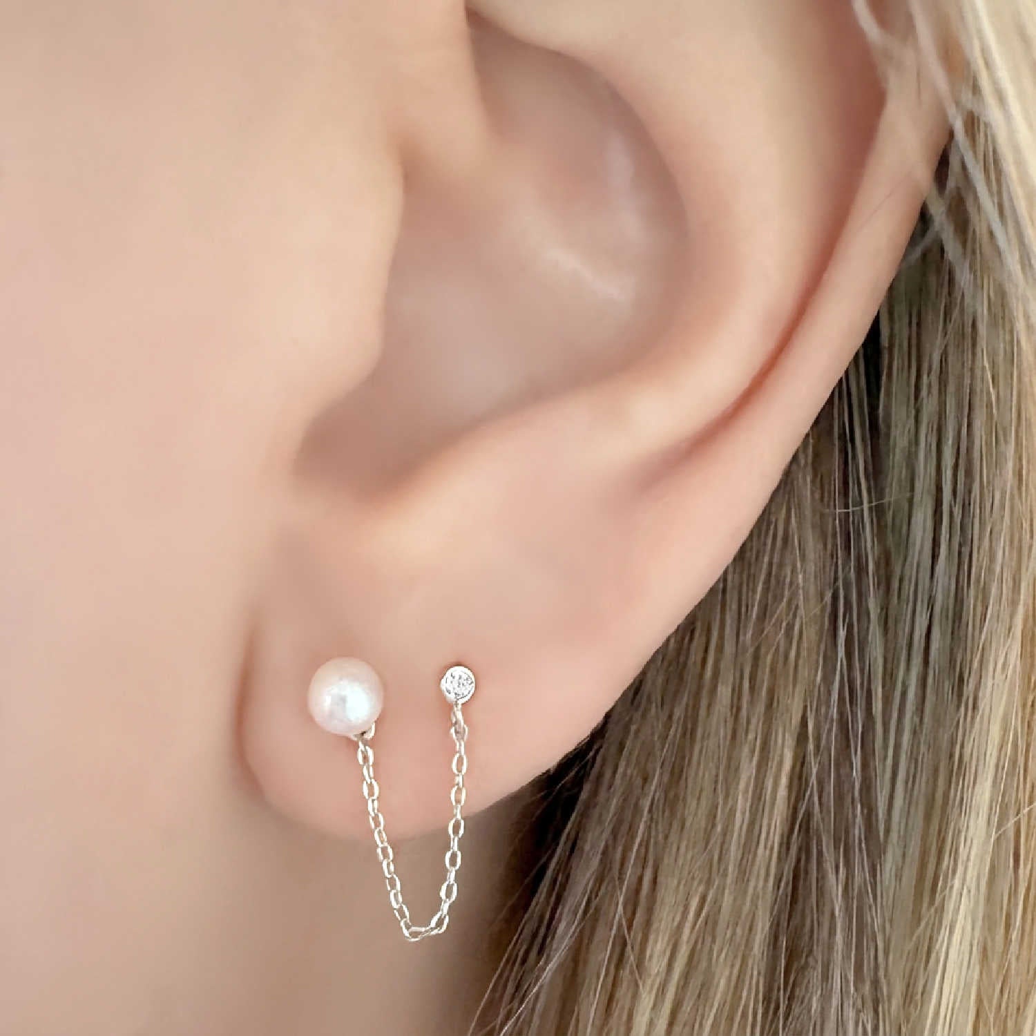 Woman wearing sterling silver double piercing earring with pearl stud