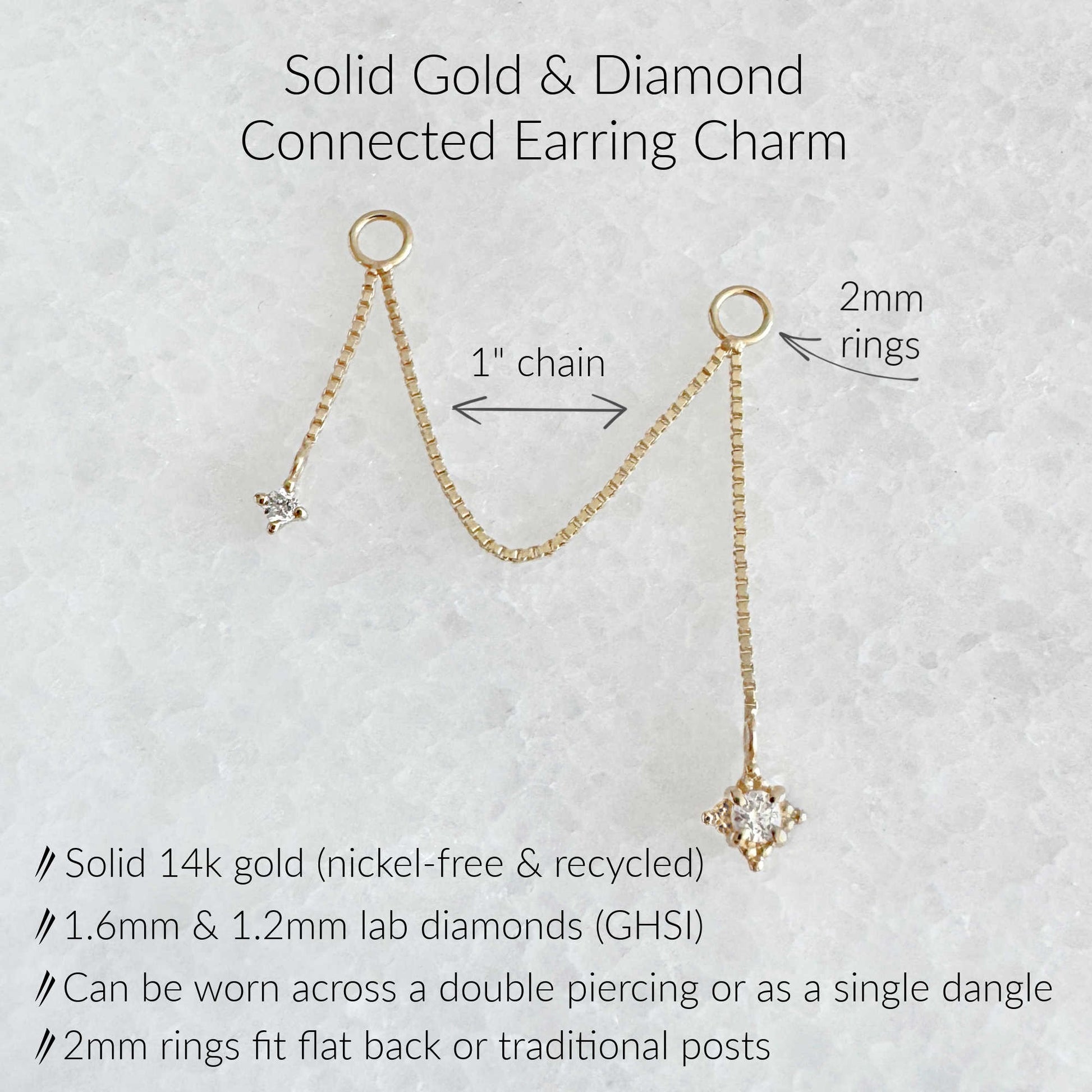 Gold dangle earring charm with a lab diamond pendant on a textured white background, featuring text labels for the 1-inch chain, 2mm rings, and product specifications.