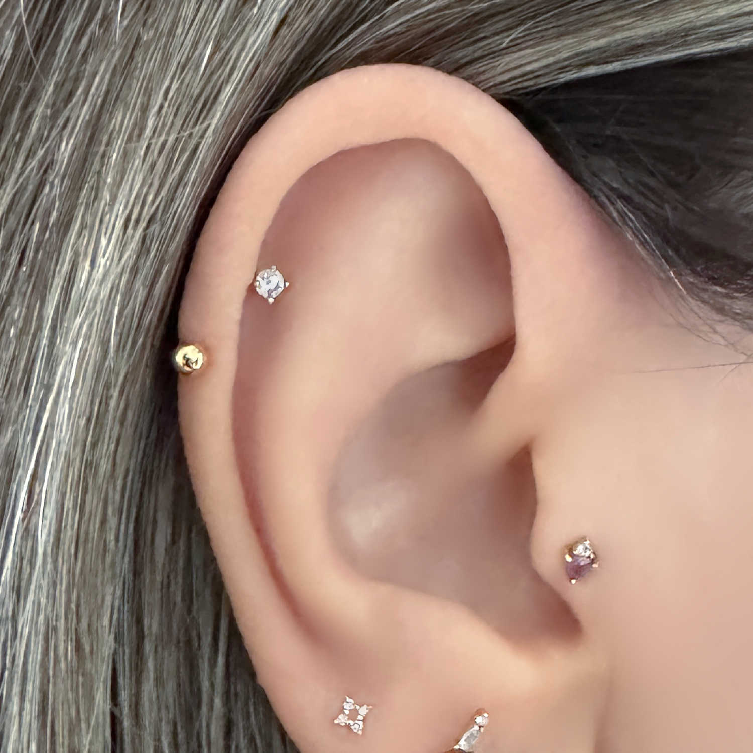 Woman wearing a horeshoe barbell earring in helix piercing