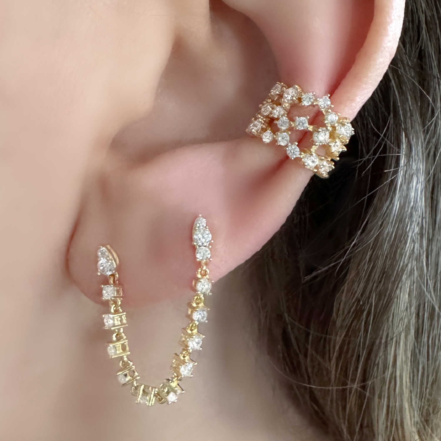 Woman Wearing Gold Chain Connected Double Piercing Tennis Earring and Wide Diamond Ear Cuff