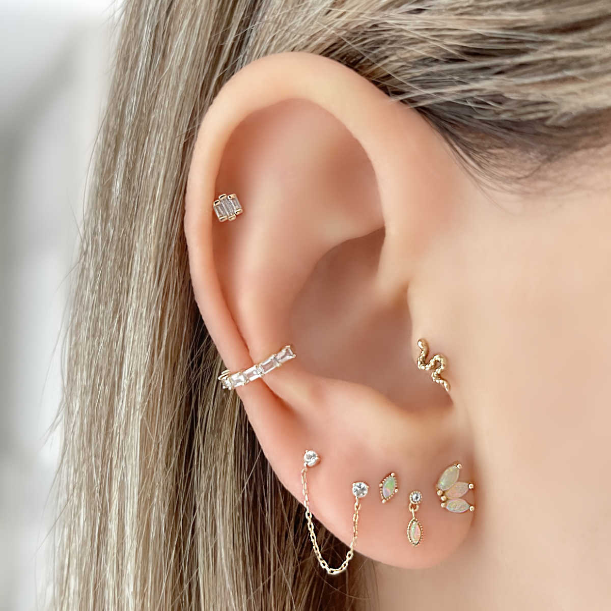 gold opal topaz helix tragus cartilage piercing stud earrings on model